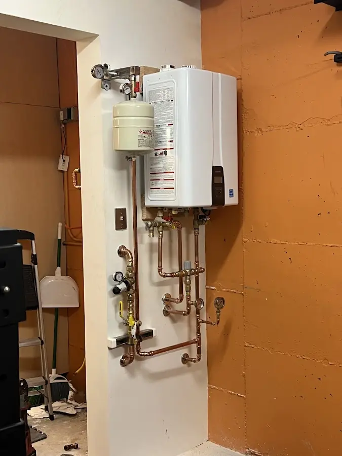 Plumbing technician inspecting water heater connections in Coquille